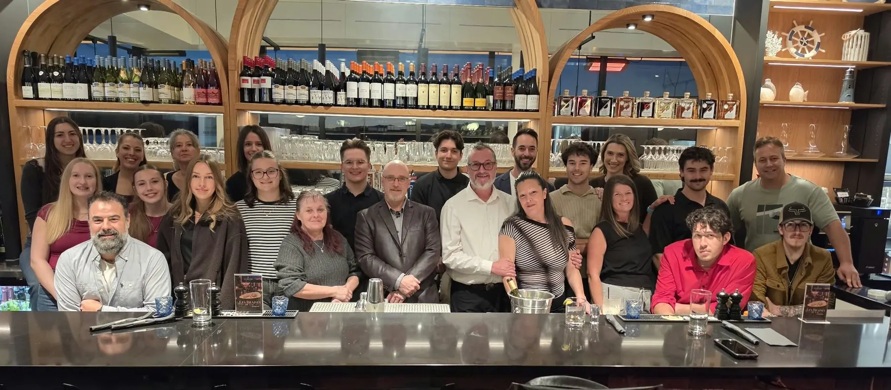 The Bistro du Lac team gathered at the bar, under the arches