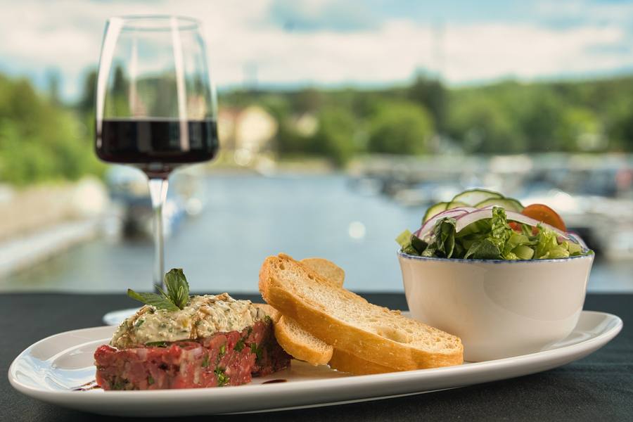 Tartare de bœuf et verre de vin face au lac